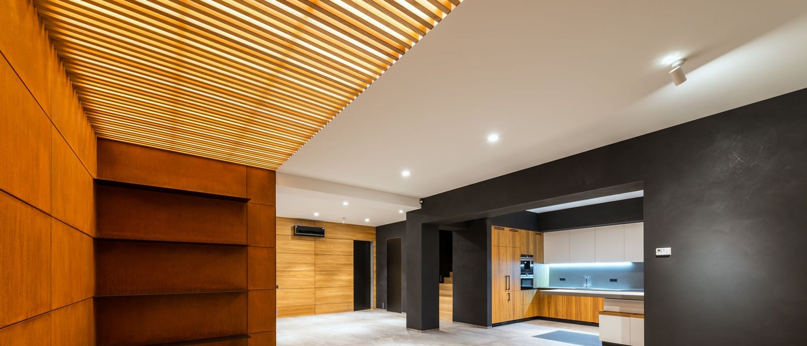 Espace de vie contemporain avec plafond bois rétroéclairé et spots encastrés